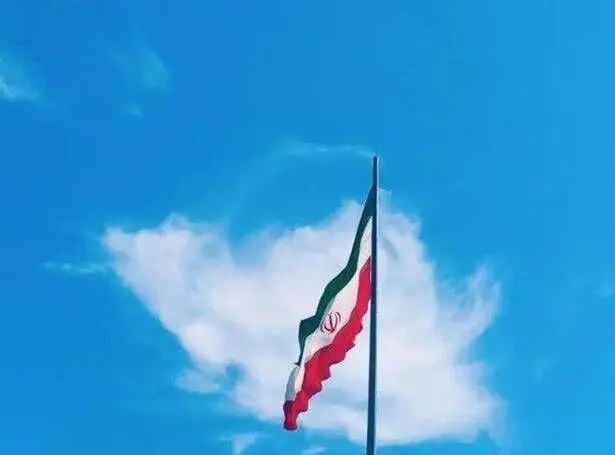 یک تصویر خاص معنادار ابر به شکل ایران در پشت پرچم ایستاده 