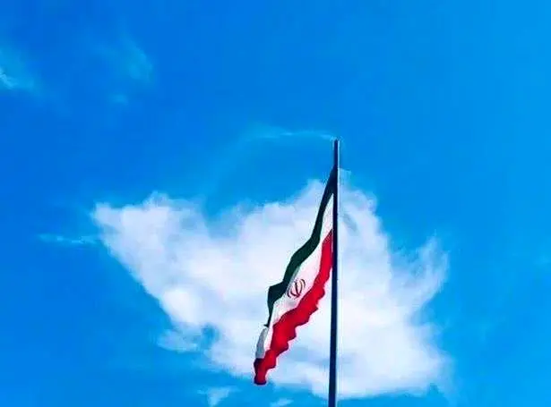 یک تصویر خاص معنادار ابر به شکل ایران در پشت پرچم ایستاده 